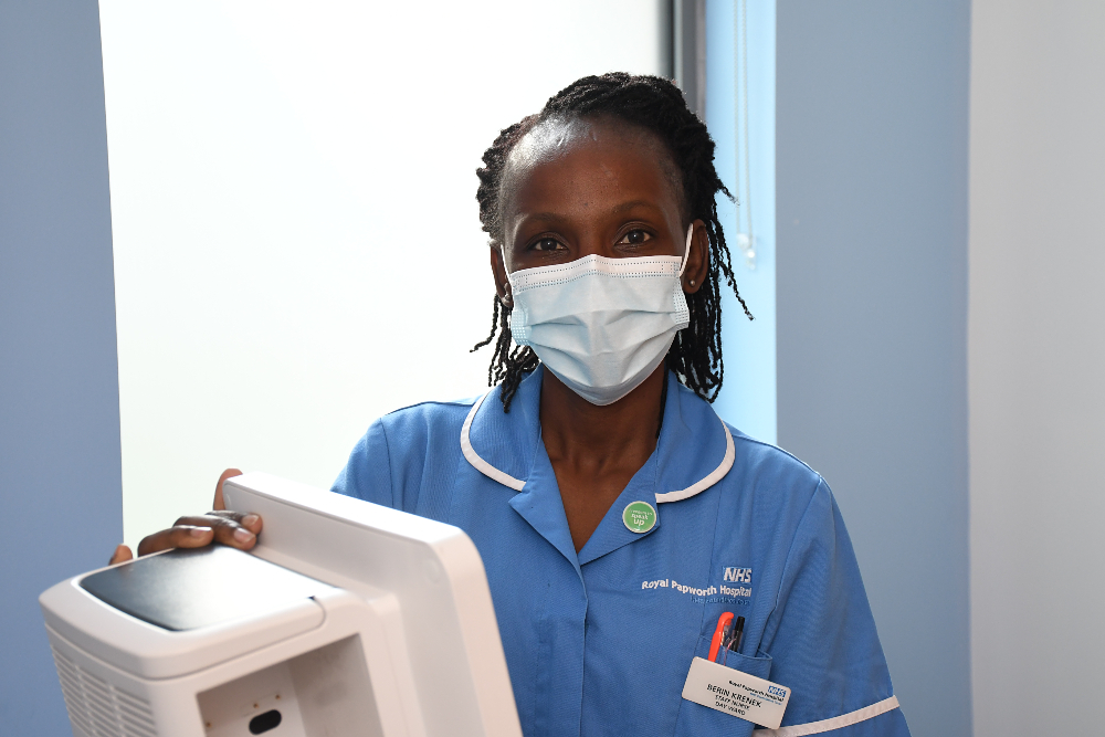 Berin wearing a mask and her blue nurse uniform 