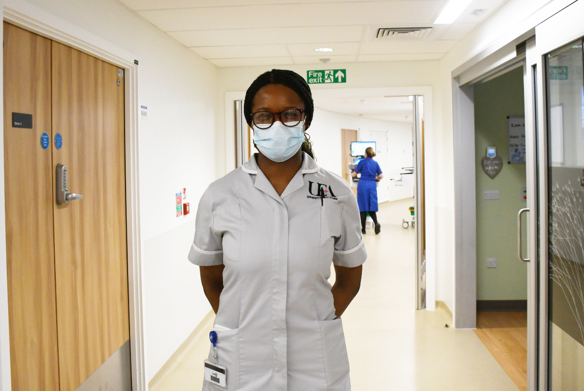 Tolu standing indoors in a hospital ward corridor 