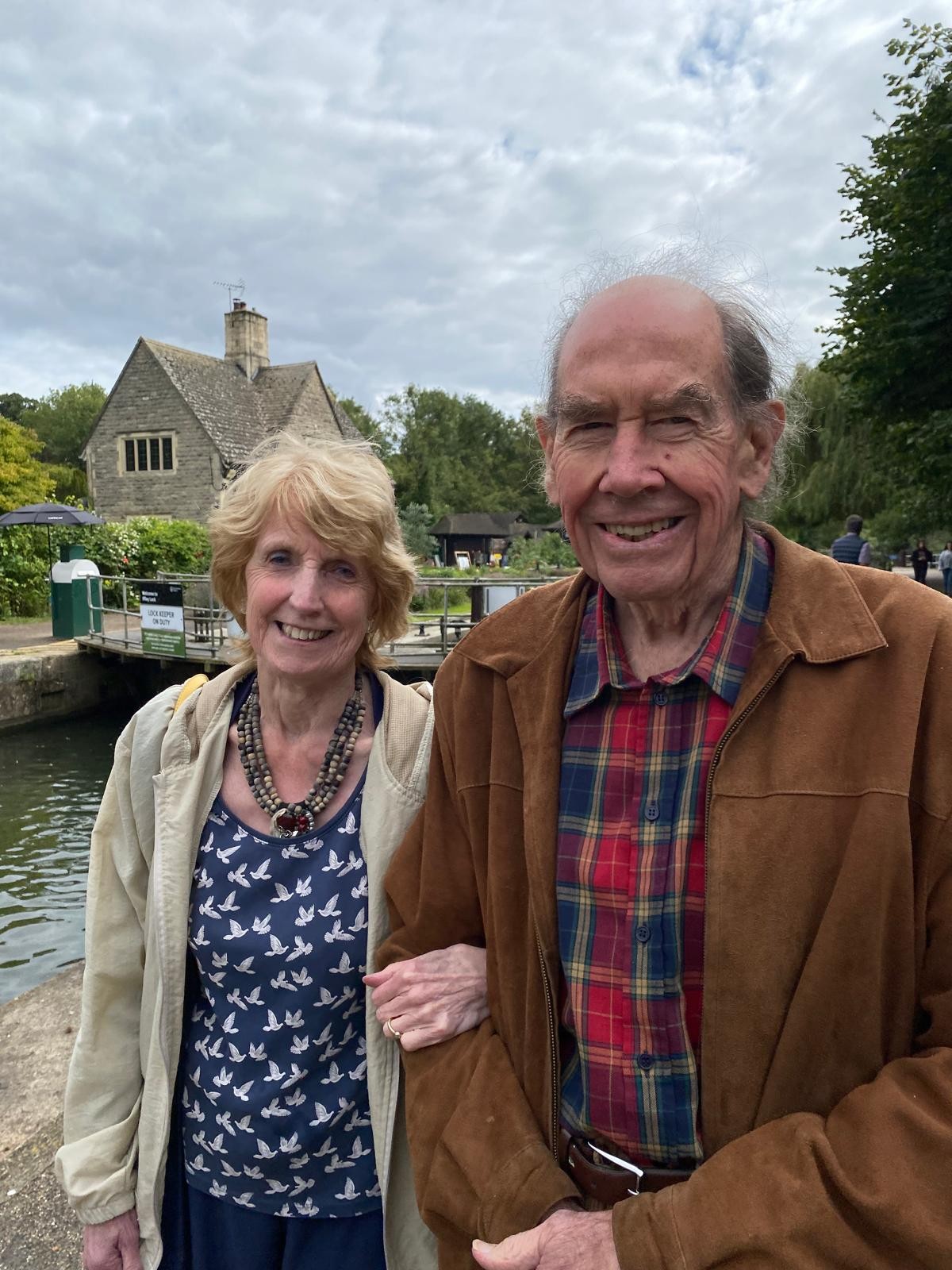 Sir Terence and his wife Judith wearing coats, outside and smiling
