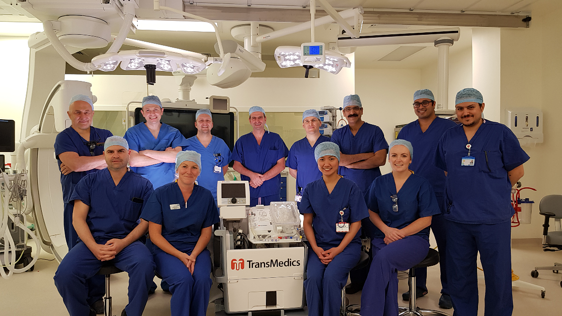 Medical staff stand together in an operating theatre.