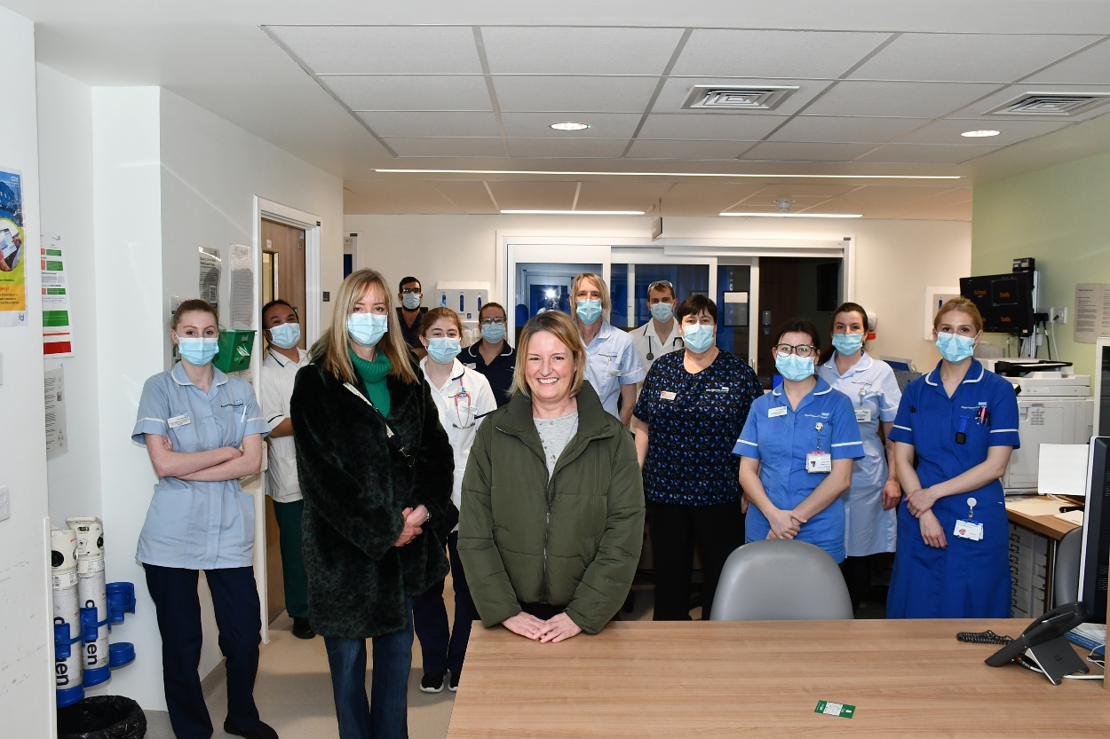 Nicola surrounded by healthcare staff on a ward. 