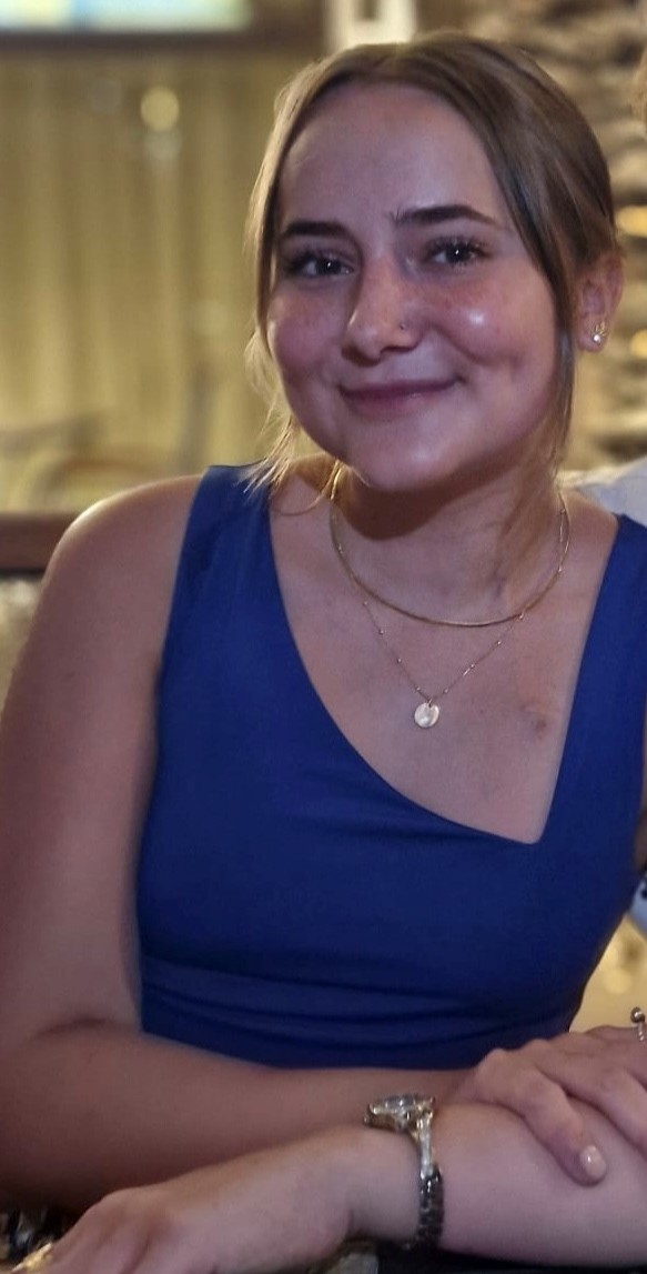A girl in a blue dress smiles at the camera