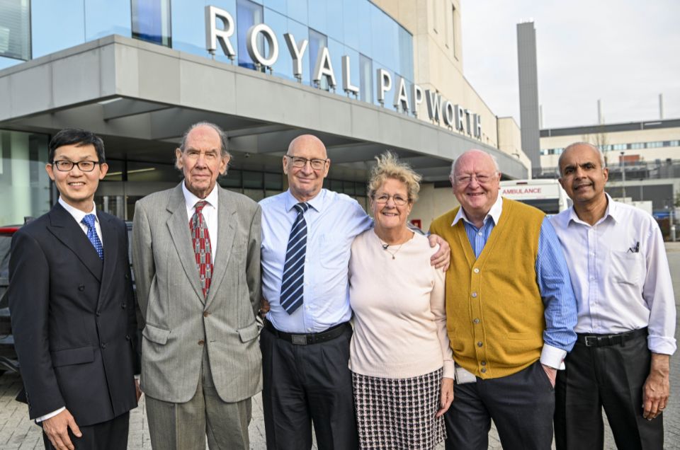 Six people standing outside a sign which says Royal Papworth