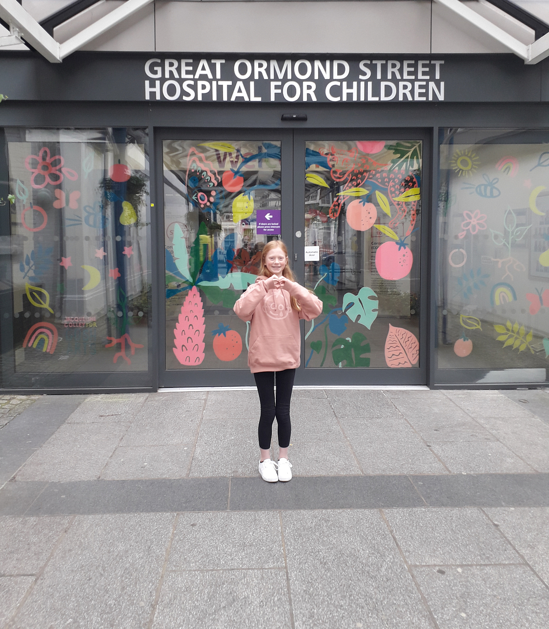 A girl stands outside Great Ormond Street Hospital for Children