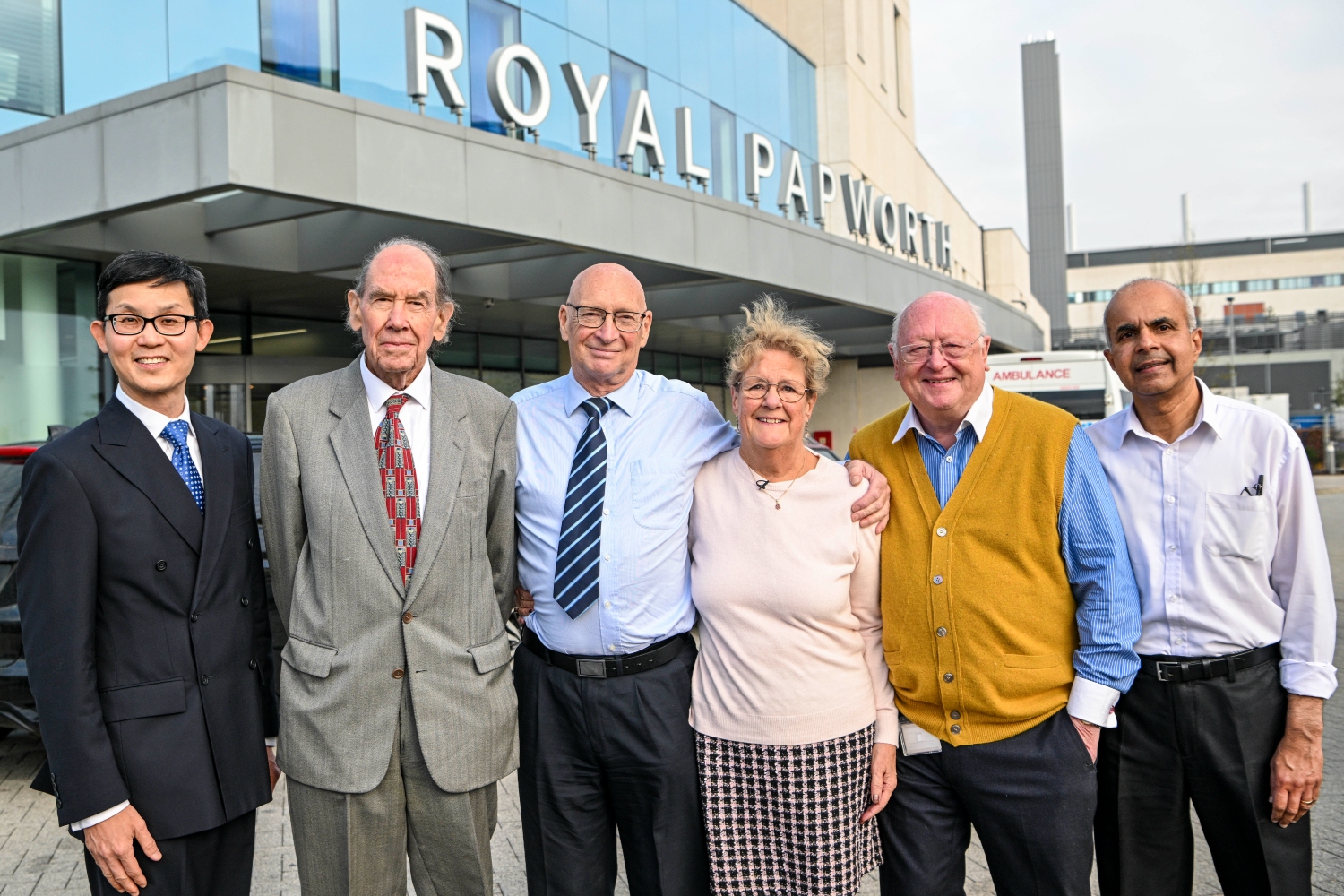 Six people standing outside a hospital building